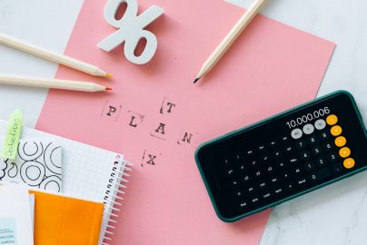 Flat lay showing tax planning tools including a calculator, pencils, and stationery items.